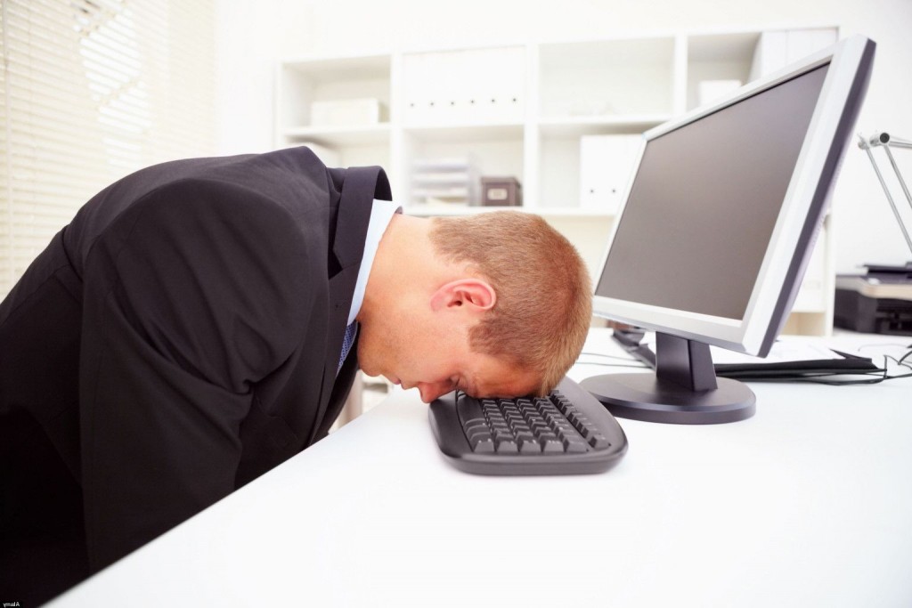Portrait of a stressed businessman with his forehead resting on the computer keyboard